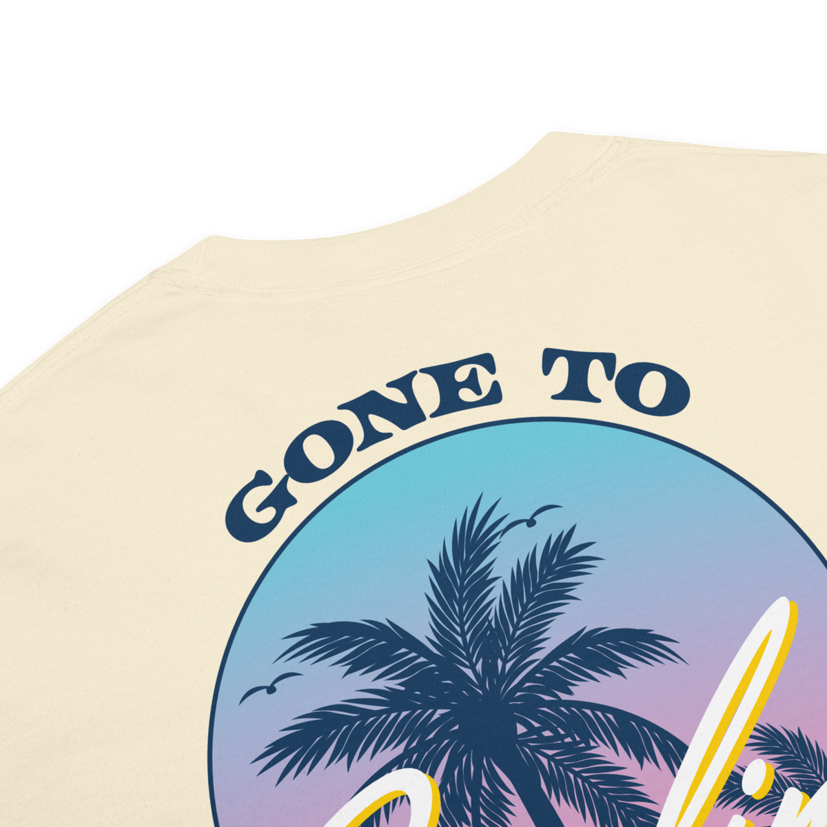 Close-up of ivory tee’s back print showing navy palm trees, a pastel sky, and ‘Gone to’ lettering.